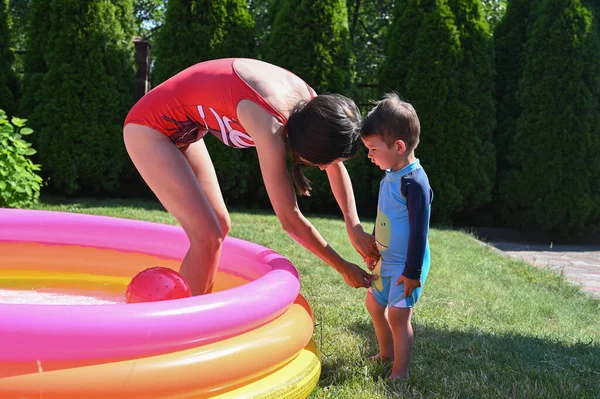 Mother and child escape from the heat in the pool — Stock Photo, Image