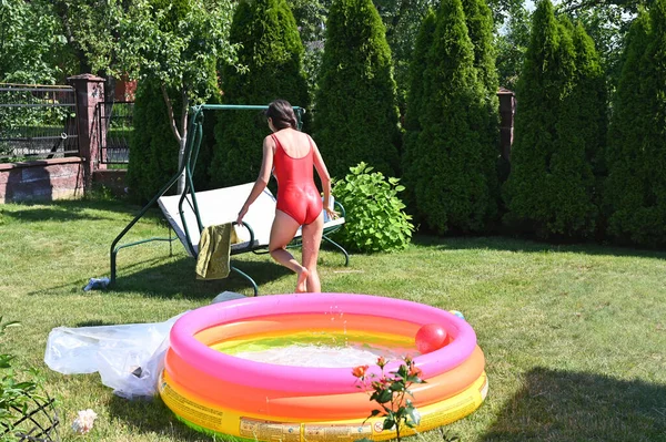 Menina e piscina inflável em casa — Fotografia de Stock