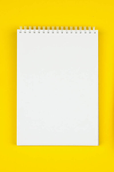 White notebook on a yellow background. High quality photo