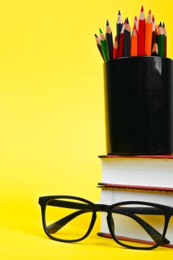 Kalemli gözlük ve sarı arka planda bir kitap. Yüksek kalite fotoğraf