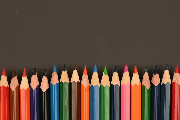 multicolored pencils on a dark school board. High quality photo