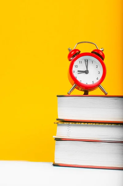 Bücher Und Rote Uhr Auf Gelbem Hintergrund Hochwertiges Foto — Stockfoto