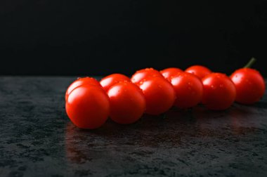 Koyu arkaplanda su olan kırmızı domatesler. Yüksek kalite fotoğraf