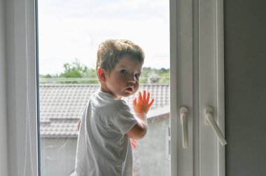 Üzgün çocuk pencereden dışarı bakıyor. Yüksek kalite fotoğraf