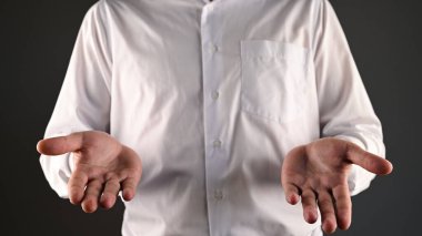 Beyaz gömlekli bir adam ellerini kullanarak yardım eder. Yüksek kalite fotoğraf