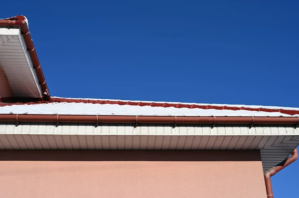 the snow on the roof of a private house melts in the sun. High quality photo