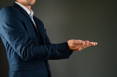 Takımlı bir adam, kollarını uzatmış destek taklidi yapıyor. Yüksek kalite fotoğraf