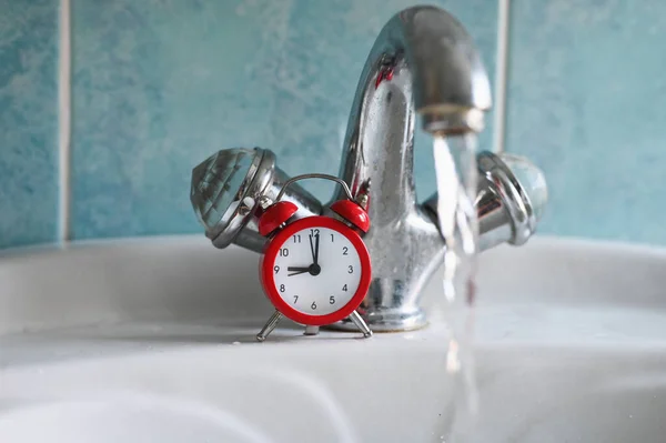 Water tap and clock. Water saving concept. High quality photo