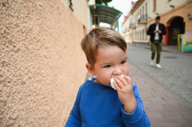 Çocuk sokakta bir pasta yiyor. Yüksek kalite fotoğraf