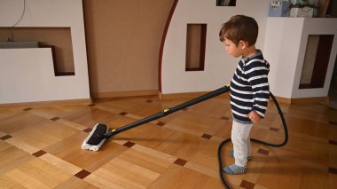Çocuk bir buhar temizleyicisiyle zemini yıkıyor. Yüksek kalite fotoğraf