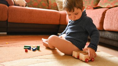 Çocuk otururken hevesle oynar. Yüksek kalite fotoğraf