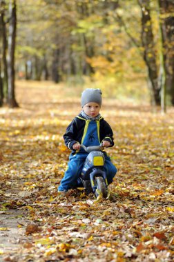 Onun motosiklet sürme küçük mutlu bir çocuk portresi