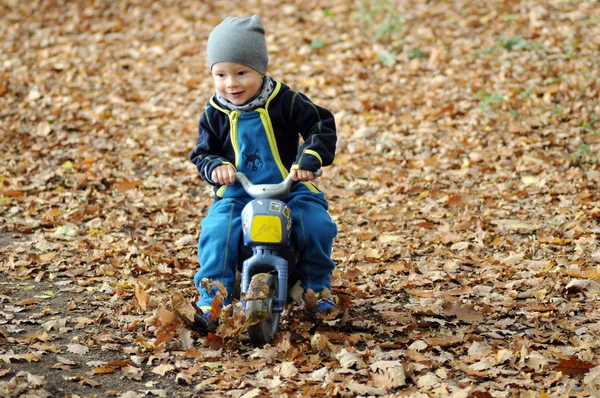 Portrait of a happy little boy riding a motorbike — Stock Photo, Image