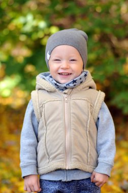 İki yıl yaşlı çocuk ayakta üzerinde düşen sonbahar yaprakları