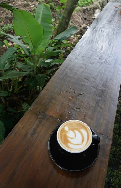 Šálek kávy s krásným Latte art na dřevěného stolku — Stock fotografie
