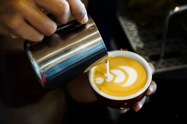 Latte sanatı yapmak için espresso kahve bardağı dondurulmuş süt dökülen barista elleri yakın Telifsiz Stok Fotoğraflar