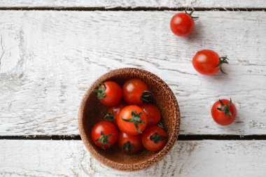Beyaz ahşap masada bir kapta taze kiraz domates