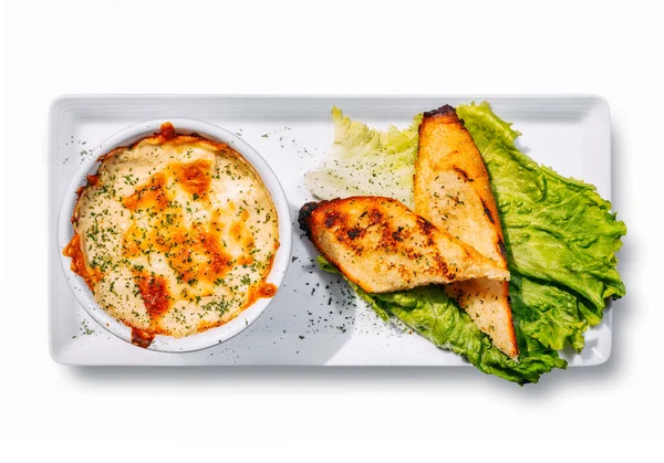 Sağlıklı yiyecekler. Beyaz arka planda mantarlı tavuk yahnisi. Yumuşak salamura edilmiş tavuk ve krem soslu mantar ve sarımsaklı tostla servis edilen peynir..