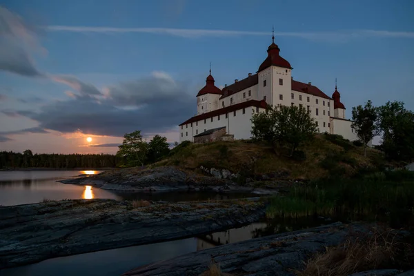 Vanern Gölü üzerinde yükselen dolunay ile akşam alacakaranlık Lacko kale uzun pozlama, Lidkping, İsveç