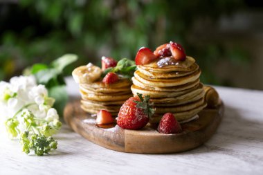 Ahşap masada çilek li krepler