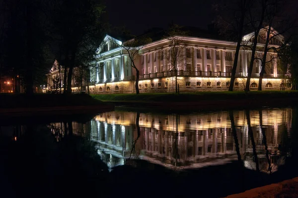 Belo edifício iluminado por luzes refletidas no rio — Fotografia de Stock