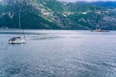 Kotor Körfezi'ndeki Uçurumun Bakiresi'nin deniz fenerine giden yalnız tekne.