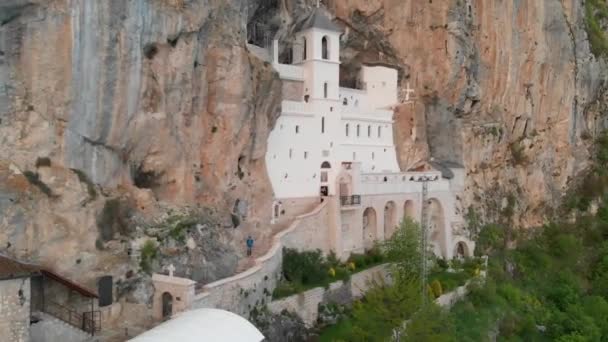 Mosteiro de Ostrog é um mosteiro da Igreja Ortodoxa Sérvia colocado contra uma rocha quase vertical de Ostroska Greda, Montenegro, Europa. É dedicado a São Basílio de Ostrog . — Vídeo de Stock