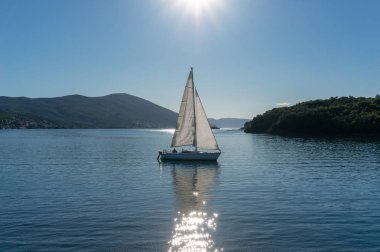 Kotor Körfezi'nde yalnız tekne yelken, Karadağ. Arka plan dağlarda yalnız tekne görünümü.