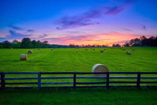 フェンスのある野原で丸い干し草のベイル — ストック写真