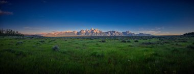 Grand Teton dağının erken güneş ışınlarının panoramik görünümü koştu