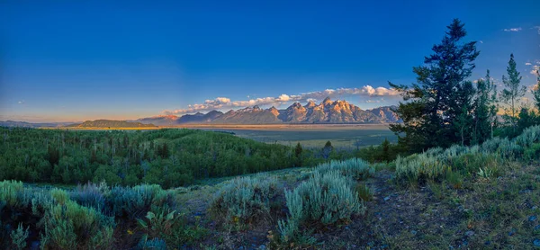 Vista panorámica de los primeros rayos del sol en la montaña Grand Teton corrió —  Fotos de Stock