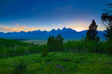 Grand Teton sıradağlarında batan güneşin görünümü.