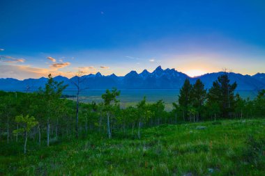 Grand Teton sıradağlarında batan güneşin görünümü.