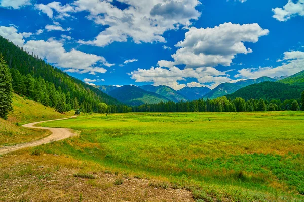 Alpejska łąka z górami — Zdjęcie stockowe