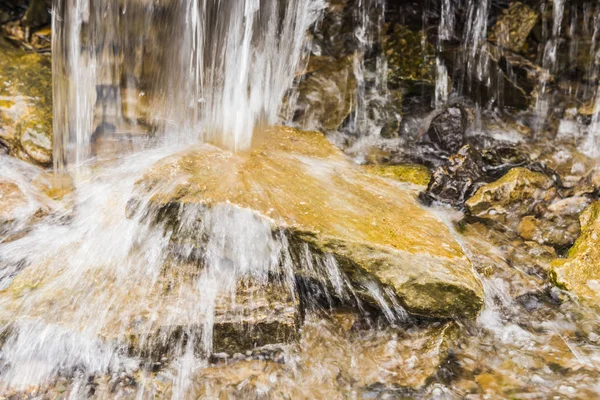 Abstraktní voda stříkající přes skály — Stock fotografie