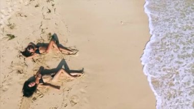 Kumsalda dinlenen iki kadının hava görüntüsü. 