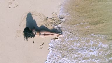 Seksi genç bayan kumsalda rahatlıyor. 