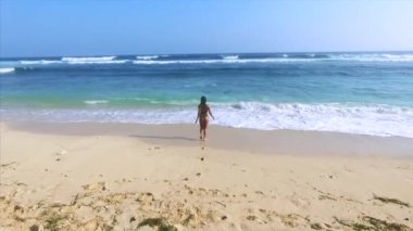 Genç ve çekici bir kadın kumsalda dinleniyor. 