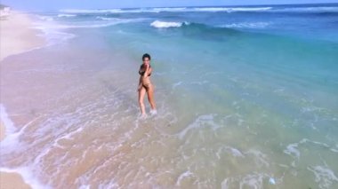 Genç ve çekici bir kadın kumsalda dinleniyor. 