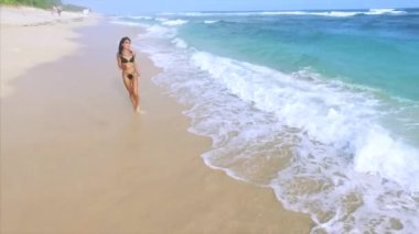 Genç ve çekici bir kadın kumsalda dinleniyor. 