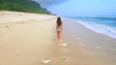 Genç ve çekici bir kadın kumsalda dinleniyor. 