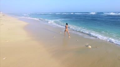 Genç ve çekici bir kadın kumsalda dinleniyor. 