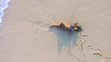 Genç ve çekici bir kadın kumsalda dinleniyor. 