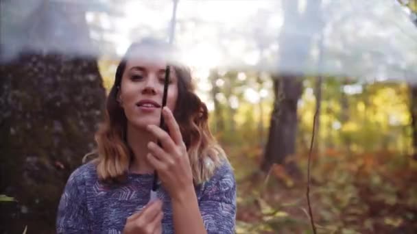有吸引力的肖像看着相机 玩透明的伞 秋天森林 — 图库视频影像