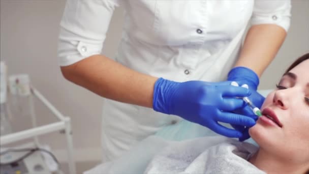 在美容诊所的年轻女子的肖像 美容师正在进行注射 口腔轮廓整形手术的程序 — 图库视频影像