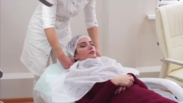 Cosmetólogo Está Preparando Procedimiento Belleza Joven Cubriendo Cabeza Con Sombrero — Vídeos de Stock