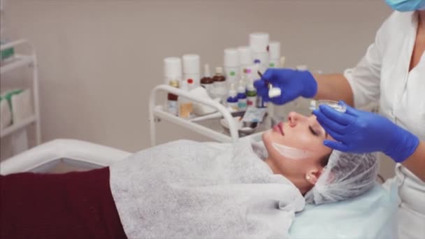 美容師は 若い女性の顔で酸素化粧品クリームを入れています 美容クリニック — ストック動画
