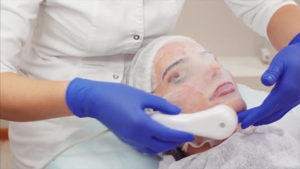 与膜面具的妇女的肖像与美丽的提炼剂在她的脸上 美容临床中的电离过程 — 图库视频影像