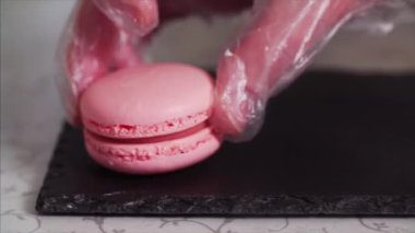Aşırı yakın pembe macaroons veya siyah tepsiye koyarak macarons Şef yukarı kayar