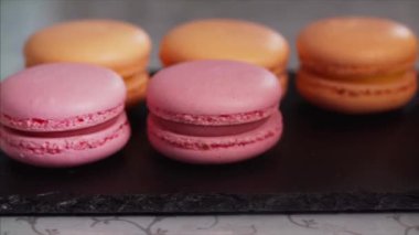 Aşırı yakın turuncu ve pembe macaroons veya siyah tepsiye koyarak macarons Şef yukarı kayar